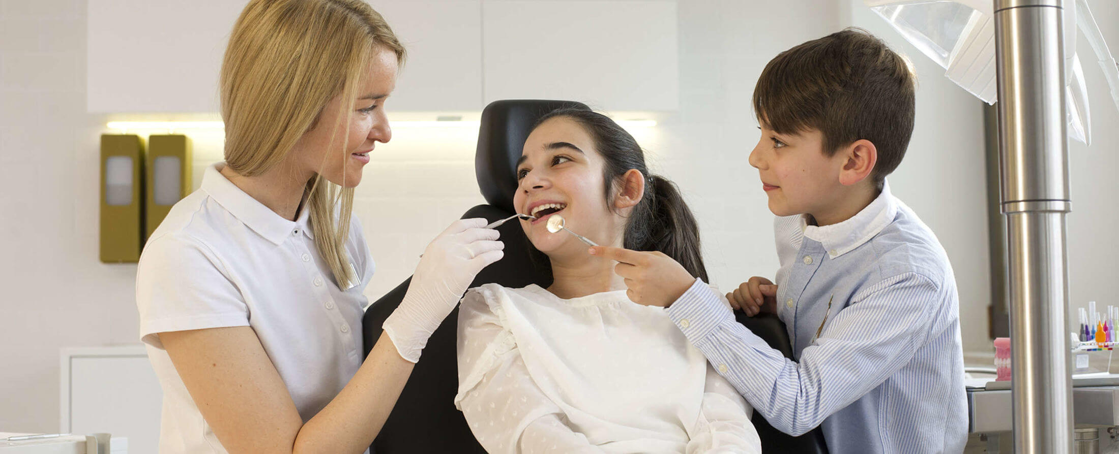 Kieferorthopäde Desislava Stanchev in Behandlung mit zwei lachenden Kindern | Brand Orthodontics Mainz